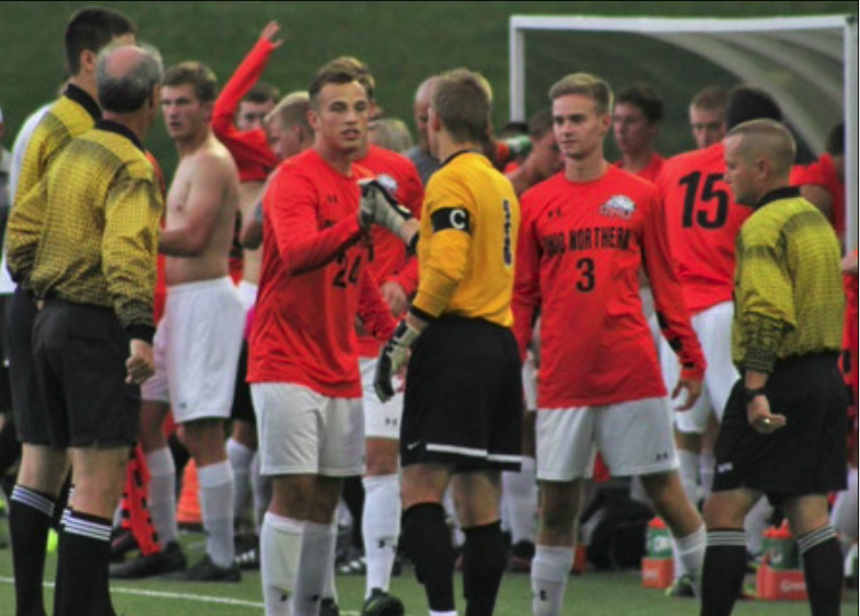David Janusz (24) and Dustin Lorenzo (3) shake hands with an official at a home game this season (Northern Review photo/Jennifer Kolb).